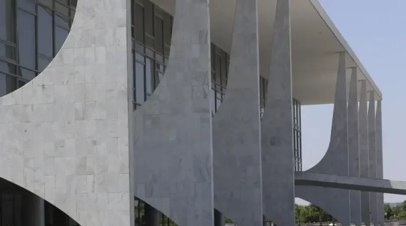 O governo federal abriu nesta quinta-feira (13) o processo formal para avaliar uma resposta às tarifas impostas pelos Estados Unidos sobre produtos brasileiros, com base na Lei da Reciprocidade Econômica. A iniciativa não representa, neste momento, uma decisão de aplicar novas tarifas ou outras medidas contra produtos norte-americanos. O objetivo é analisar os efeitos das medidas adotadas pelos Estados Unidos e verificar se estão presentes as condições previstas na legislação brasileira para eventual adoção de contramedidas. O procedimento foi iniciado a partir do compartilhamento do pedido pela Secretaria-Executiva da Câmara de Comércio Exterior (Camex) com os demais integrantes do Comitê-Executivo de Gestão (Gecex). Paralelamente, o Ministério das Relações Exteriores (MRE) deverá notificar o governo dos Estados Unidos e solicitar a abertura de consultas diplomáticas. Segundo o Palácio do Planalto, as consultas têm como objetivo buscar a redução ou a eliminação dos efeitos das medidas norte-americanas e de eventuais contramedidas previstas na Lei nº 15.122, de 2025. O governo afirmou que pretende priorizar o diálogo e a negociação nas relações internacionais, mas declarou que continuará defendendo a posição brasileira diante das tarifas aplicadas pelos Estados Unidos. A Lei da Reciprocidade Econômica foi aprovada em 2025 e estabelece mecanismos para que o Brasil responda a ações, políticas ou práticas unilaterais de outros países que prejudiquem a competitividade brasileira. Entre as possibilidades previstas estão a suspensão de concessões comerciais e outras medidas compatíveis com compromissos assumidos pelo país no comércio internacional. A legislação determina que as respostas devem, sempre que possível, guardar proporção com o prejuízo econômico provocado pela medida adotada por outro país. O processo aberto nesta quinta-feira ocorre após o governo dos Estados Unidos impor novas tarifas sobre produtos brasileiros. Em julho, o Escritório do Representante Comercial dos Estados Unidos (USTR) determinou uma sobretaxa de 25% sobre diversos produtos do Brasil. A medida atingiu setores como ferro e aço, vestuário, calçados, açúcar, etanol, produtos farmacêuticos, máquinas agrícolas e máquinas elétricas não destinadas ao setor de aviação, além de outros produtos manufaturados. Posteriormente, uma sobretaxa adicional de 12,5% foi aplicada a outros produtos brasileiros, sob a alegação de que o Brasil não adotaria mecanismos suficientes para impedir a entrada de mercadorias produzidas com trabalho forçado. Com isso, as tarifas chegaram a 37,5% para parte das exportações brasileiras destinadas ao mercado norte-americano. De acordo com levantamento do Ministério do Desenvolvimento, Indústria, Comércio e Serviços (MDIC), as novas tarifas atingem cerca de US$ 6,6 bilhões em exportações brasileiras para os Estados Unidos. O governo brasileiro já havia recorrido ao sistema de solução de controvérsias da Organização Mundial do Comércio (OMC) para questionar as tarifas norte-americanas. Na avaliação do Brasil, as medidas são incompatíveis com as regras estabelecidas pela organização. Os Estados Unidos aceitaram participar das consultas solicitadas pelo governo brasileiro no âmbito da OMC. Desde o início das novas taxações, o governo brasileiro também tem destacado que os Estados Unidos mantêm superávit na relação comercial bilateral, ou seja, exportam mais para o Brasil do que importam do país. O argumento é utilizado pelo governo para contestar a justificativa das tarifas e defender a necessidade de negociação entre os dois países. Ao anunciar a abertura do processo de reciprocidade, o governo federal afirmou que seguirá adotando medidas para reduzir os impactos das tarifas sobre a economia brasileira e a renda da população. Entre as estratégias mencionadas estão a defesa do multilateralismo, a reforma da OMC, a diversificação das parcerias comerciais e a busca por novos mercados para produtos brasileiros. O governo também informou que manterá ações de proteção aos setores afetados pelas tarifas por meio do Plano Brasil Soberano, com medidas voltadas à preservação de empregos e da capacidade produtiva nacional. A abertura do processo, portanto, inicia uma análise formal sobre a possibilidade de resposta comercial do Brasil. Qualquer eventual contramedida dependerá da conclusão dessa avaliação e deverá seguir os mecanismos previstos na legislação brasileira.